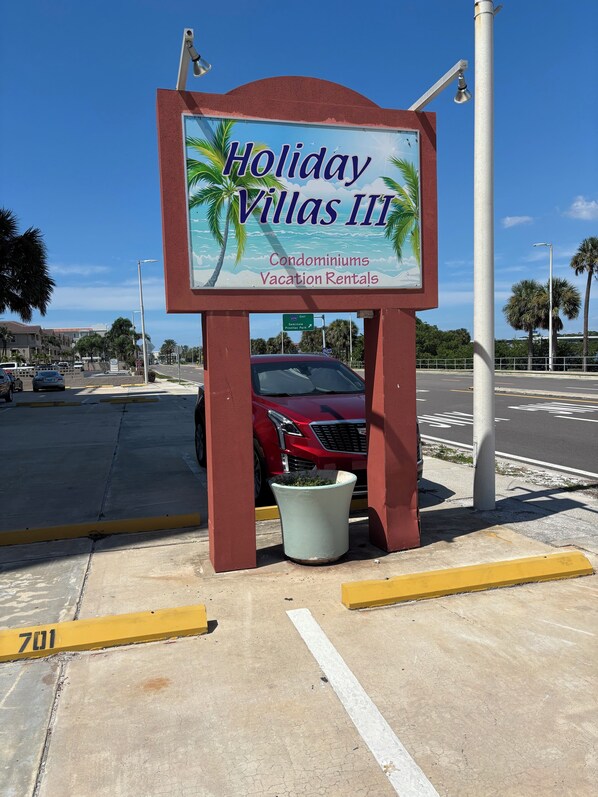 Une enseigne indiquant « Holiday Villas III » et faisant la publicité de copropriétés et de locations de vacances.