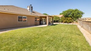 A house with a large backyard, a covered patio, and a chimney. - Zion's Edge! Entire Home with Views, 20 Min from Zion N.P., Sleeps 10 (La Verkin)