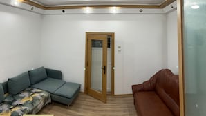 A room with a wooden ceiling, a door, a green sofa, and a brown sofa. - Casa din Tei Brasov by BuySellRent (Brașov)