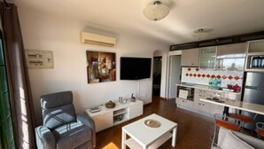 A modern living room with a grey sofa, a white coffee table, and a TV mounted on the wall.