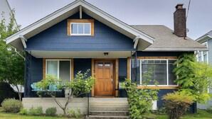 A two-story house with a front porch, a wooden door, and a chimney. - The Burke House Collection by Stay Rested  (Seattle)