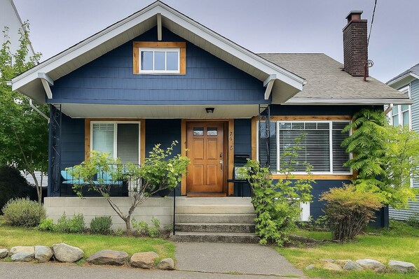 A two-story house with a front porch, a wooden door, and a chimney. - The Burke House Collection by Stay Rested  (Seattle)