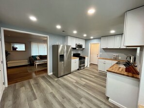A compact kitchen with a refrigerator, microwave, stove, and sink. - Recently Renovated 3BR/2BA Cozy Home in Fresno, CA (Fresno)
