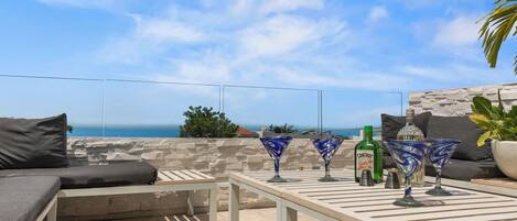 An outdoor seating area with a table, cushions, and decorative glasses.