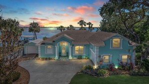 A two-story house with a front porch, a garage, and a well-maintained lawn.