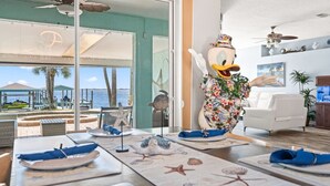A dining area with a view of the sea, a decorative duck statue, and a white sofa. - Game Room • Theater •Luxurious Waterfront Retreat• (Melbourne)