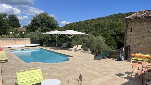 A swimming pool with lounge chairs and umbrellas, surrounded by stone walls and greenery. - La Téolière (countryside and private pool) (FIGANIERES)