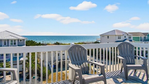 A deck with chairs overlooking a beach and ocean. - Tee Off by Brunswick Vacation Rentals: 6 Bedrooms with Amazing Views & Pool! (Ocean Isle Beach)