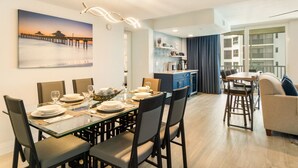Un espace repas moderne avec une table en verre, des chaises et une vue sur une jetée.