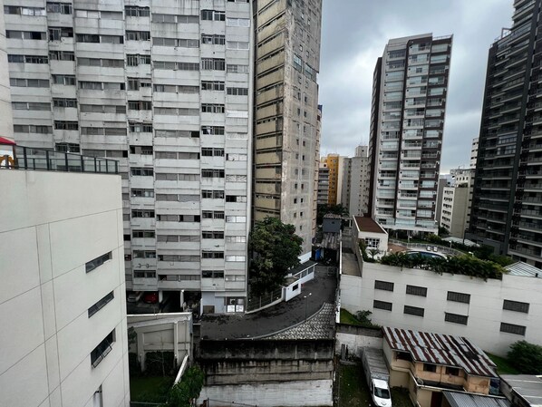 Un quartier urbain dense, caractérisé par de nombreux immeubles de grande hauteur, dont un bâtiment blanc imposant doté de nombreuses fenêtres et de balcons.