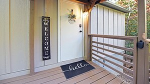 A wooden deck with a welcome mat and a door with a 'WELCOME' sign. - Peaceful retreat, next to a Winery with a fire pit. Pet friendly (Young Harris)