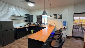 Cafetera o tetera, frigorífico grande y placa de cocina