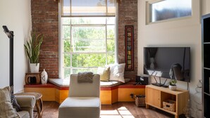 Una sala de estar acogedora con un ventanal grande, un televisor y una zona de estar confortable.