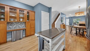 A modern kitchen with wooden cabinets, a stainless steel refrigerator, and a central island.