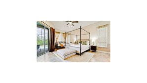 Un espacioso dormitorio con cama con dosel, un ventanal con cortinas y un ventilador de techo.
