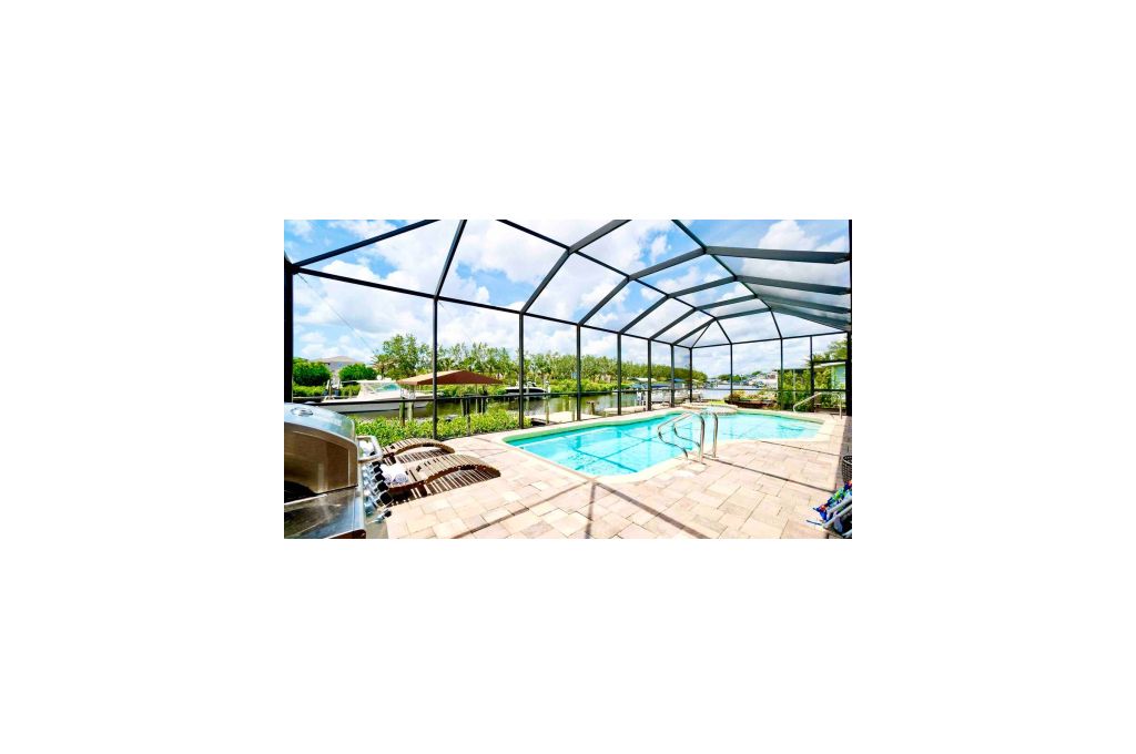 Une piscine extérieure couverte, avec un ciel dégagé au-dessus, entourée d’une structure en métal.