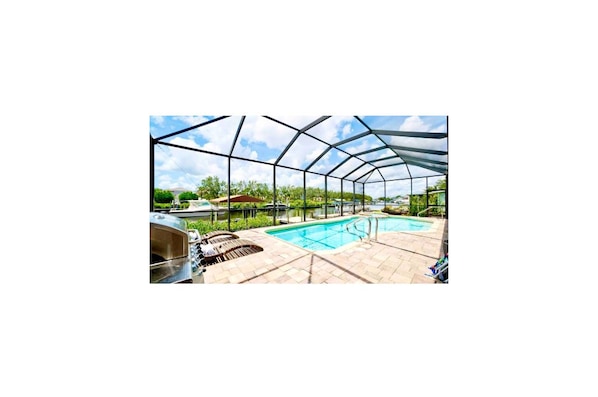 Une piscine extérieure couverte, avec un ciel dégagé au-dessus, entourée d’une structure en métal.