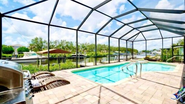 Una piscina cubierta al aire libre con cielo despejado, rodeada por una estructura de metal.