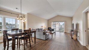 Un vaste espace de vie comprenant une table à manger, un canapé et des fauteuils.
