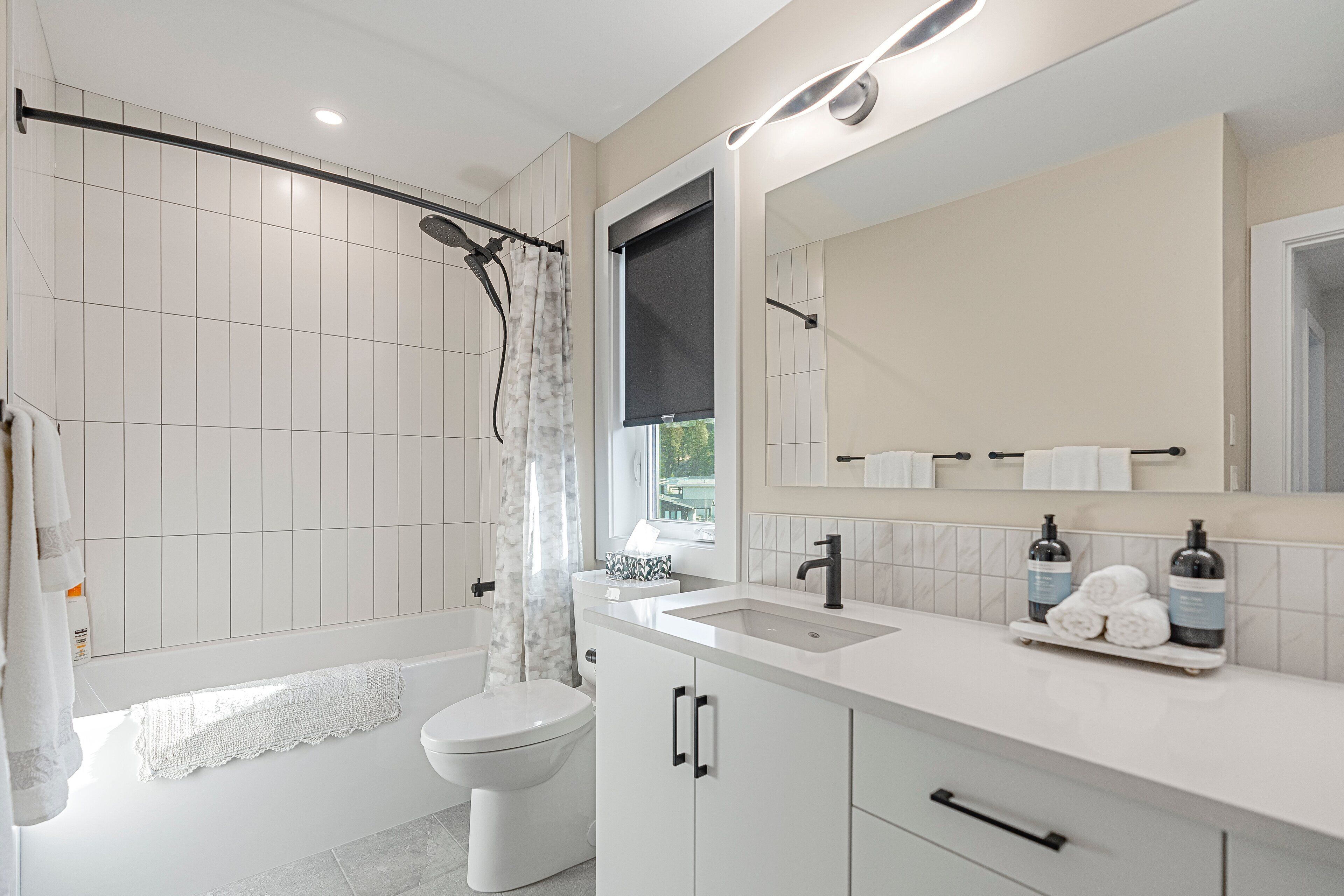 Ein modernes Badezimmer mit Badewanne, Toilette und Waschbecken.