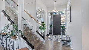 Ein modernes Interieur mit Treppe, einer Bank und Topfpflanzen.