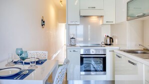 Una cucina moderna con mobili bianchi, forno integrato e lavello.