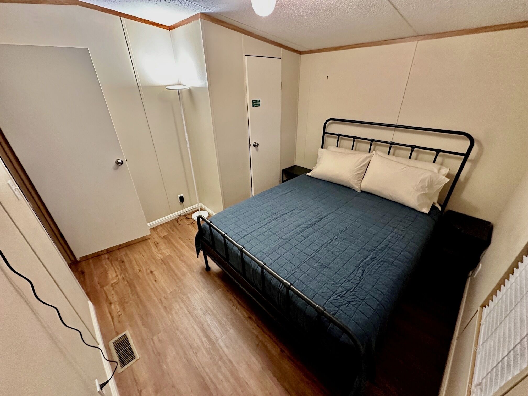 Une chambre à coucher avec un lit, une armoire et une porte.