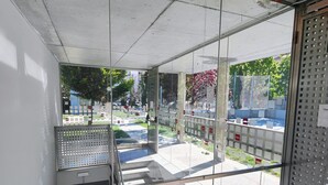 Ein modernes Interieur mit Glaswand, Metalltreppe und Betondecke.