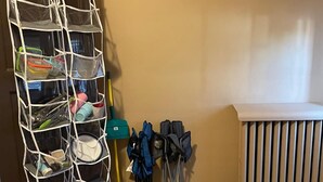 A room with a storage unit, a radiator, and a broom. - Cozy Private Room in Historic Findlay Home with Kitchen, Wifi and Free Parking (Findlay)