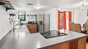 A modern kitchen with a stainless steel refrigerator, built-in oven, and a granite countertop. - Lux gated condo in Sabino Cyn, relax, explore & create memories 4ever. Book now! (Tucson)
