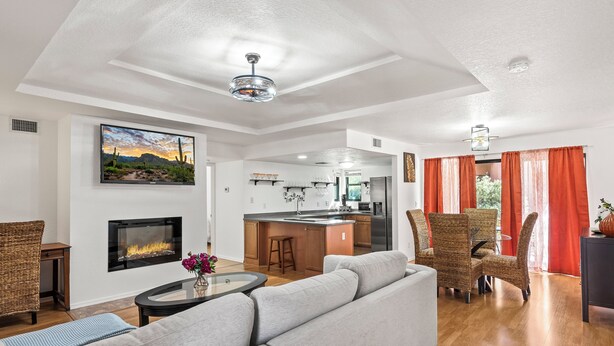 A modern living room with a fireplace, a kitchen, and a dining area. - Lux gated condo in Sabino Cyn, relax, explore & create memories 4ever. Book now! (Tucson)