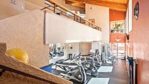 A gym with various exercise equipment, a second-floor balcony, and a view of the outside. - Lux gated condo in Sabino Cyn, relax, explore & create memories 4ever. Book now! (Tucson)