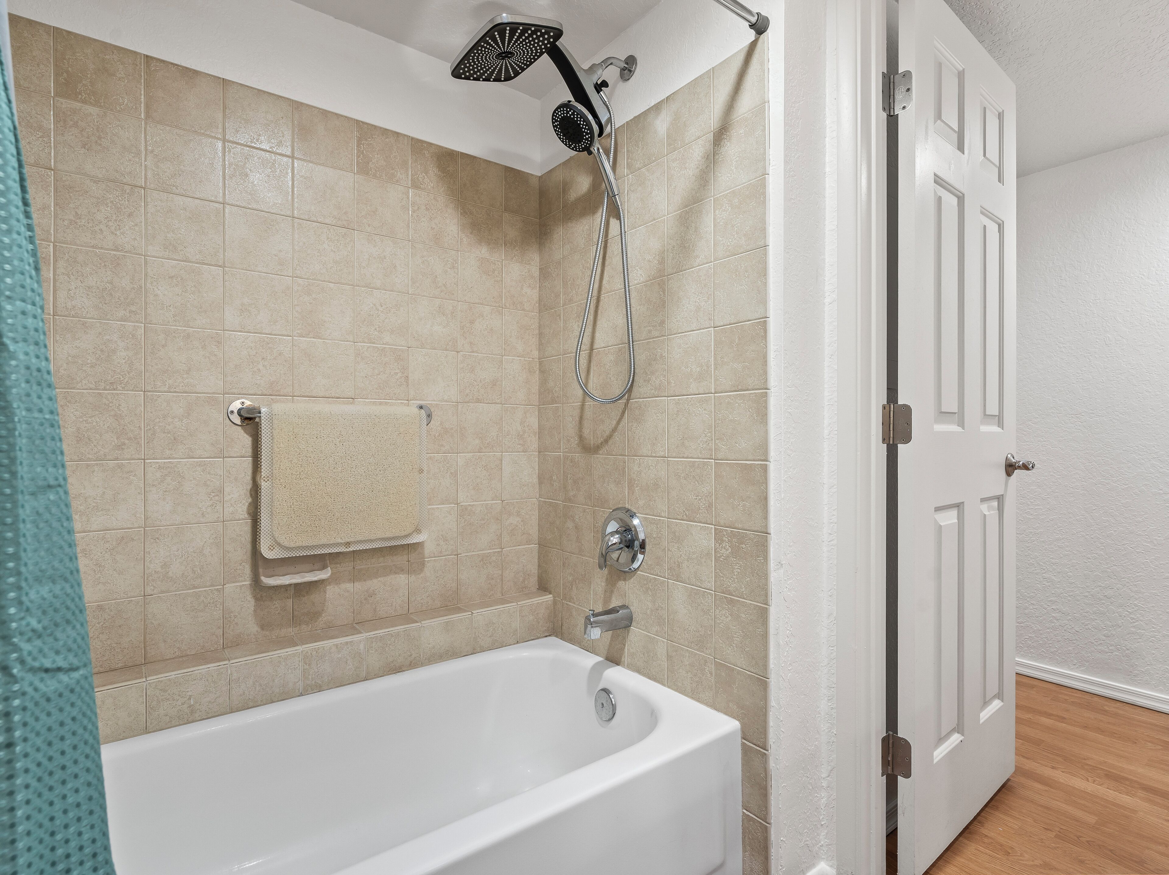 Ein Badezimmer mit Badewanne, Duschkopf und Handtuchhalter.