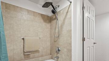 Ein Badezimmer mit Badewanne, Duschkopf und Handtuchhalter.