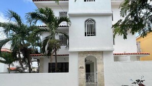 Un edificio blanco con un arco central, varias ventanas y un balcón.