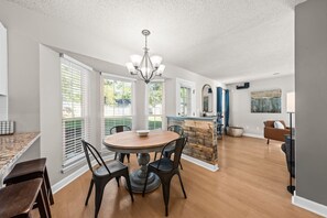 A dining area with a round table, chairs, and a chandelier. - Space for 10+ and Fenced Yard, The Indigo House! (North Charleston)