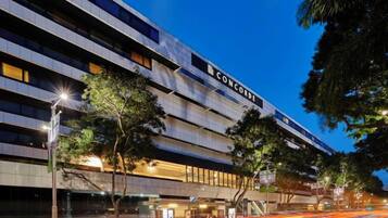 A multi-story hotel with a modern architectural design, featuring a prominent signage and a well-lit facade.