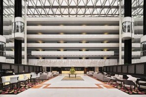 A spacious lobby with multiple seating areas, a reception desk, and a high ceiling with a geometric pattern. - Concorde Hotel Singapore (Singapore)
