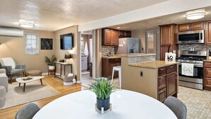 Una cocina moderna con armarios de madera, un refrigerador de acero inoxidable y un horno empotrado.