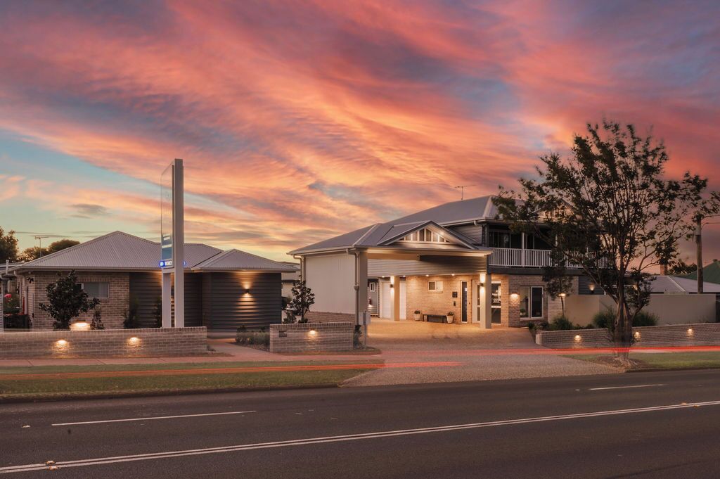 A modern two-story house with a garage, a driveway, and a street view.