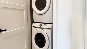 Une buanderie équipée de deux machines à laver à chargement frontal superposées.