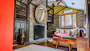 Una sala de estar acogedora con chimenea de piedra, una mesa de centro de madera y un sofá cómodo.