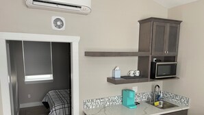 A compact kitchen with a microwave, a coffee maker, and a sink. - Adorable 1-bedroom Guesthouse for Travel Professional (Kennewick)