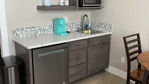 A compact kitchen with a dishwasher, a coffee maker, a microwave, and a sink. - Adorable 1-bedroom Guesthouse for Travel Professional (Kennewick)
