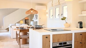 A modern kitchen with a central island, built-in oven, and pendant lighting. - Villa Provençale **** | 5 bedrooms | swimming pool (Sainte-Maxime)
