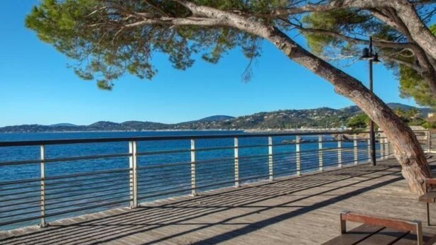 A wooden boardwalk with benches, a railing, and a view of the sea and hills. - Villa *** 120m² | sea view | 800m from the beaches (Les Issambres)