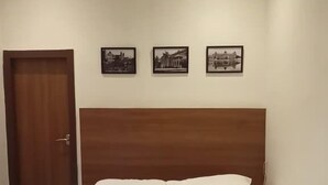 Ein ordentlich bezogenes Bett mit Handtüchern und einem Bilderrahmen auf einer gestreiften Bettdecke.