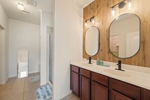 Une salle de bain avec deux lavabos, un lambris en bois et un grand miroir.