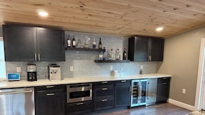 Eine moderne Küche mit dunklen Schränken, Edelstahlgeräten und einer gefliesten Spritzschutzwand.