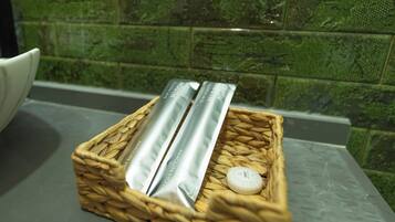 A woven basket containing two silver containers and a small white object on a countertop.